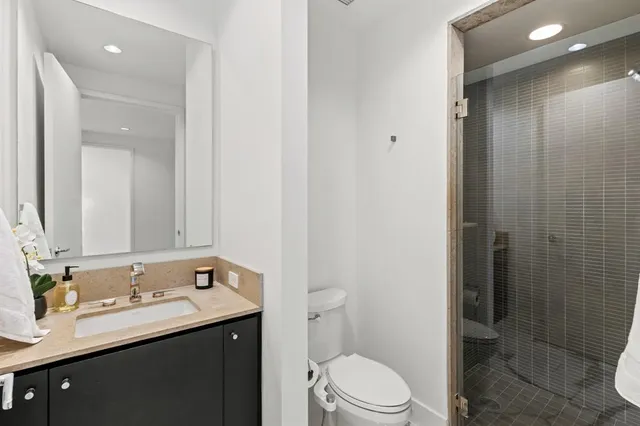 a bathroom with a granite countertop sink toilet and shower