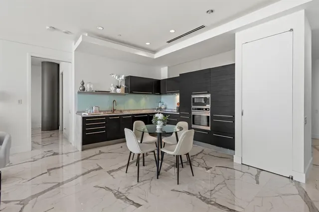 a kitchen with stainless steel appliances kitchen island granite countertop a refrigerator and a stove top oven