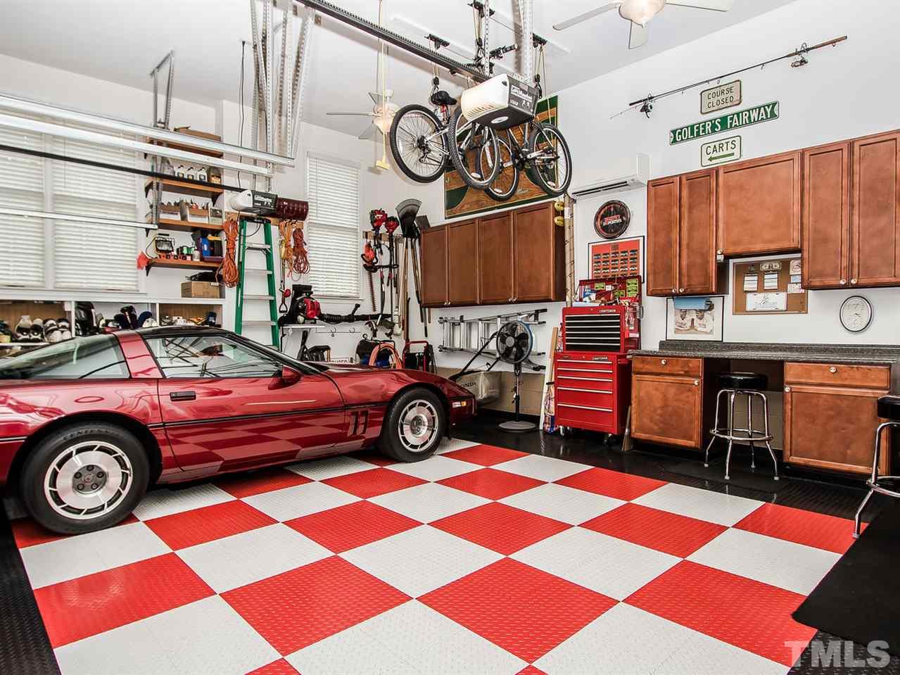 11636 Broadfield Court Raleigh, NC 27617 - Photo 16 of 25 Oversized 2 car garage is not your usual garage. It offers overhead storage, custom golf bag stands, separate heat and A/C, 6' counter w cabinets and overhead cabinets as well.