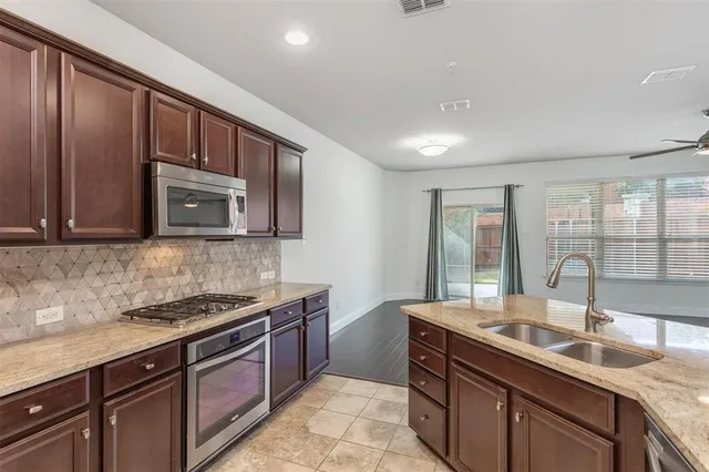 a kitchen with stainless steel appliances granite countertop a sink stove and cabinets