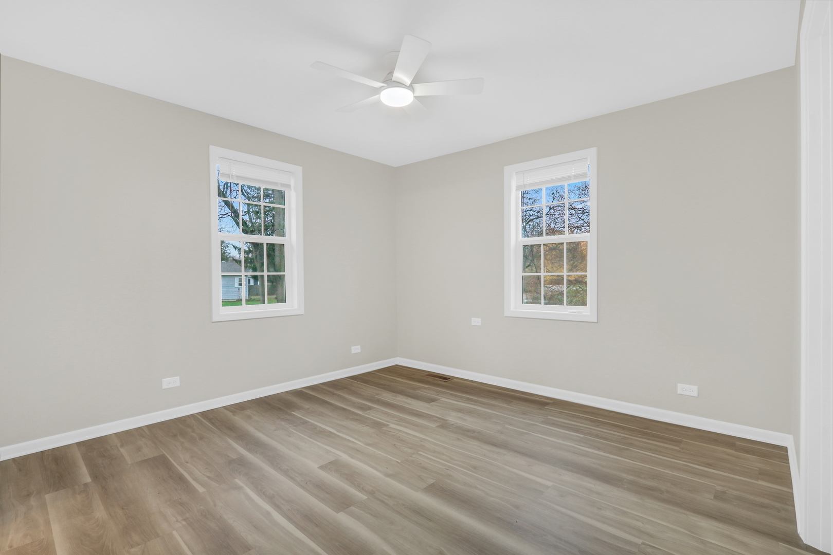 24791 West Rollins Road Round Lake, IL 60073 - Photo 12 of 26 an empty room with wooden floor and windows