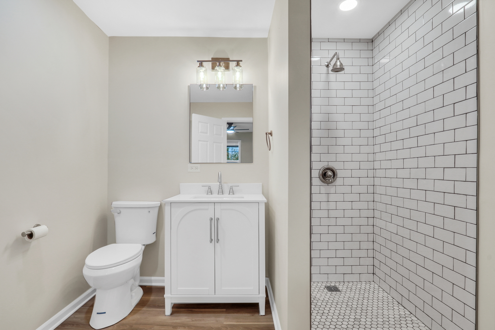 24791 West Rollins Road Round Lake, IL 60073 - Photo 14 of 26 a bathroom with a toilet a sink a shower and mirror