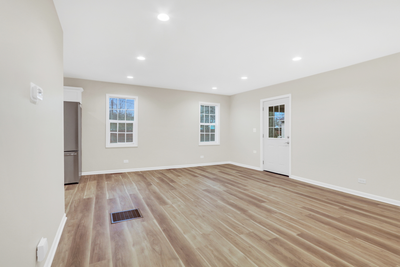 24791 West Rollins Road Round Lake, IL 60073 - Photo 3 of 26 an empty room with wooden floor and windows