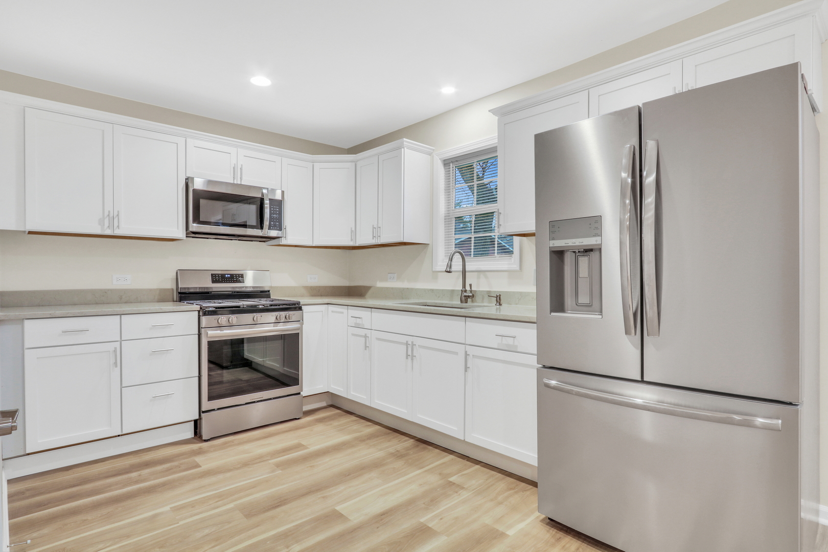 24791 West Rollins Road Round Lake, IL 60073 - Photo 6 of 26 a kitchen with stainless steel appliances white cabinets and a refrigerator