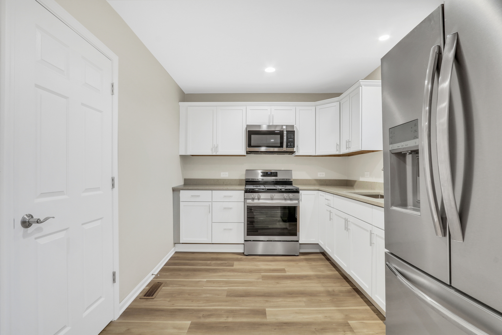 24791 West Rollins Road Round Lake, IL 60073 - Photo 7 of 26 a kitchen with white cabinets and stainless steel appliances