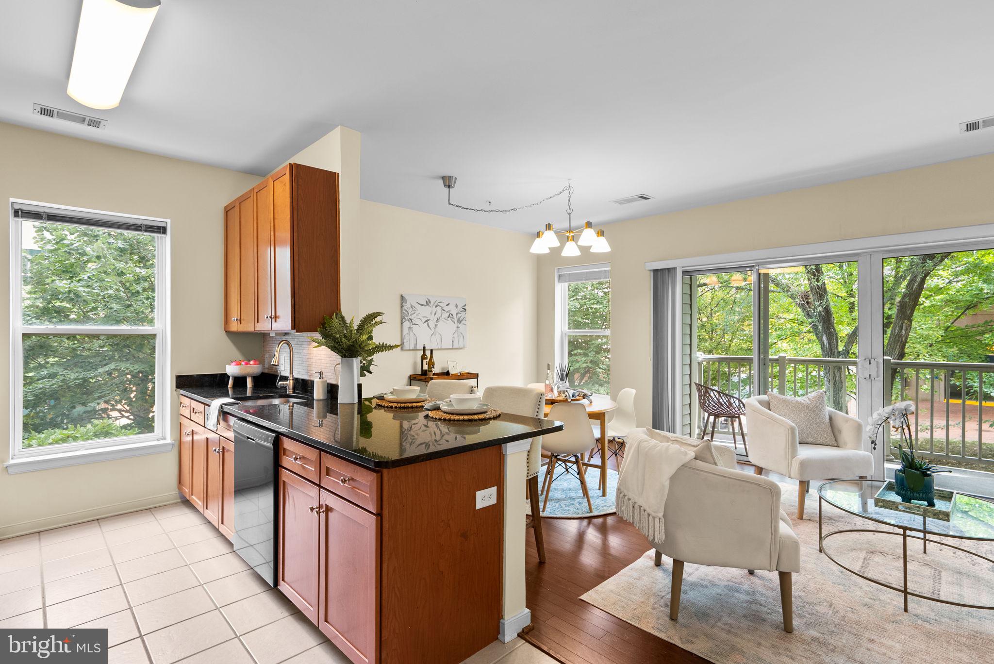 a kitchen with kitchen island granite countertop a stove dining table chairs and a large window