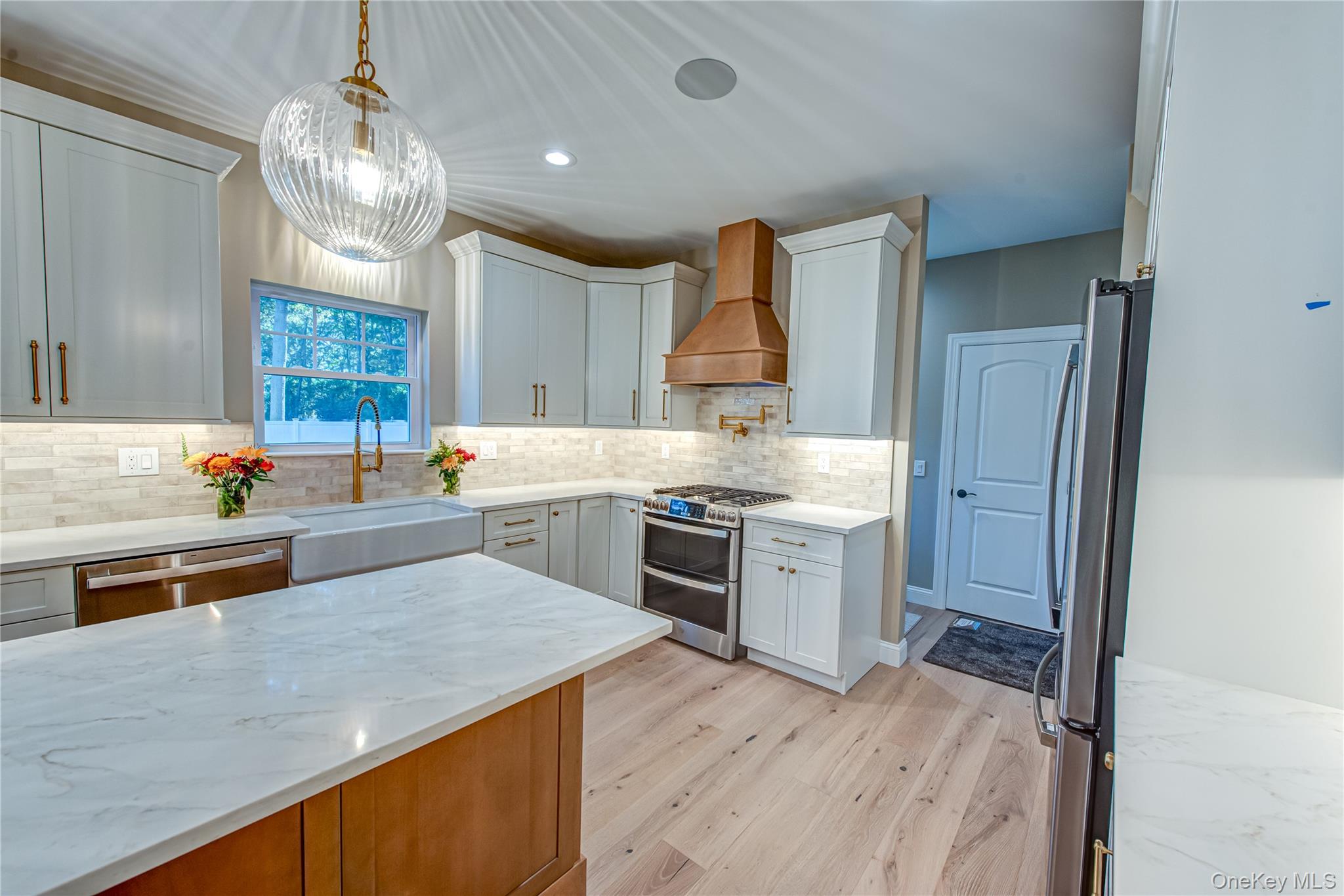 64 Blydenburgh Road Centereach, NY 11720 - Photo 23 of 44 Kitchen with recessed lighting, light stone countertops, appliances with stainless steel finishes, light wood finished floors, and custom range hood. For Marketing Purposes!