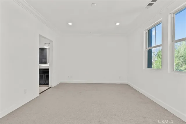 an empty room with a fireplace and windows