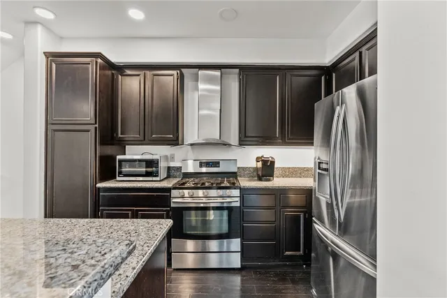 a kitchen with stainless steel appliances granite countertop a refrigerator stove and oven