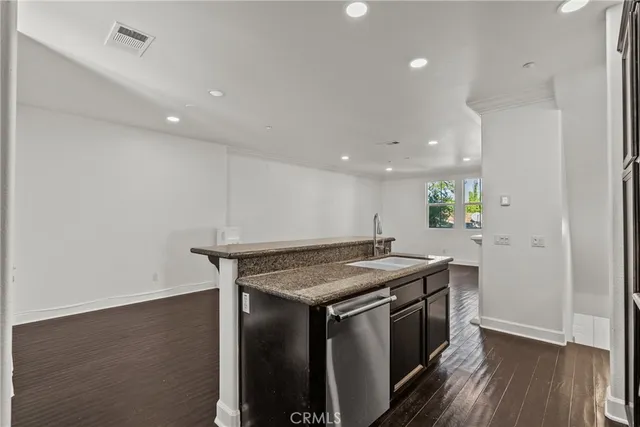 a kitchen with a stove and a wooden floor