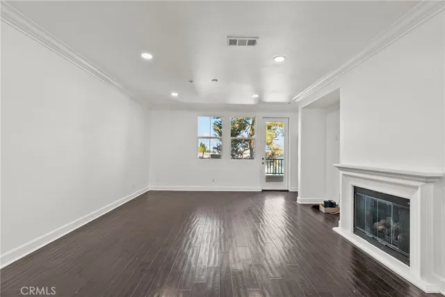 an empty room with windows and fireplace