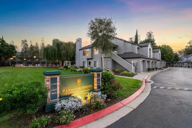 a view of a house with a yard and potted plants