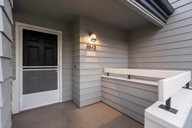 a front view of a house with garden and trees