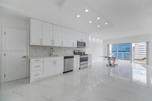 a kitchen with stainless steel appliances white cabinets and a refrigerator