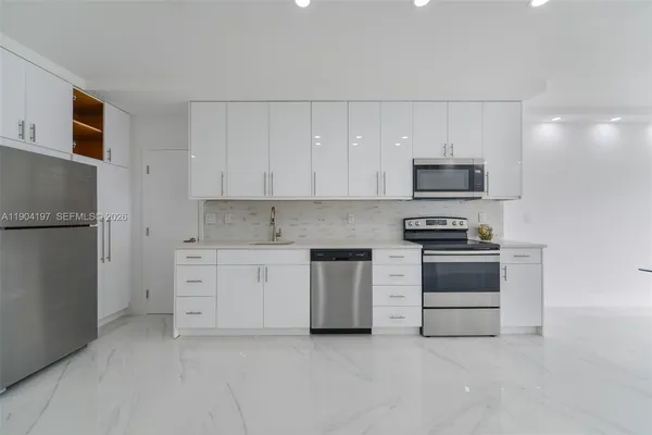 a kitchen with white cabinets and stainless steel appliances
