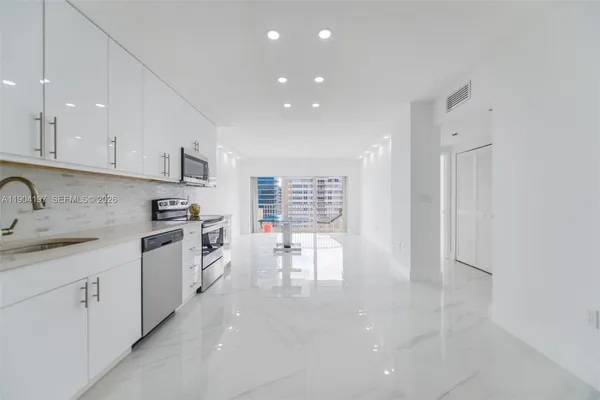 a kitchen with stainless steel appliances a refrigerator sink and cabinets