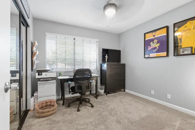 a view of a workspace with furniture and a window