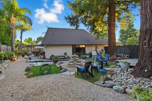 a view of a chairs and table in backyard