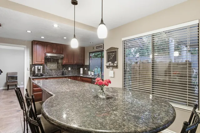 a kitchen with sink refrigerator dining table and chairs