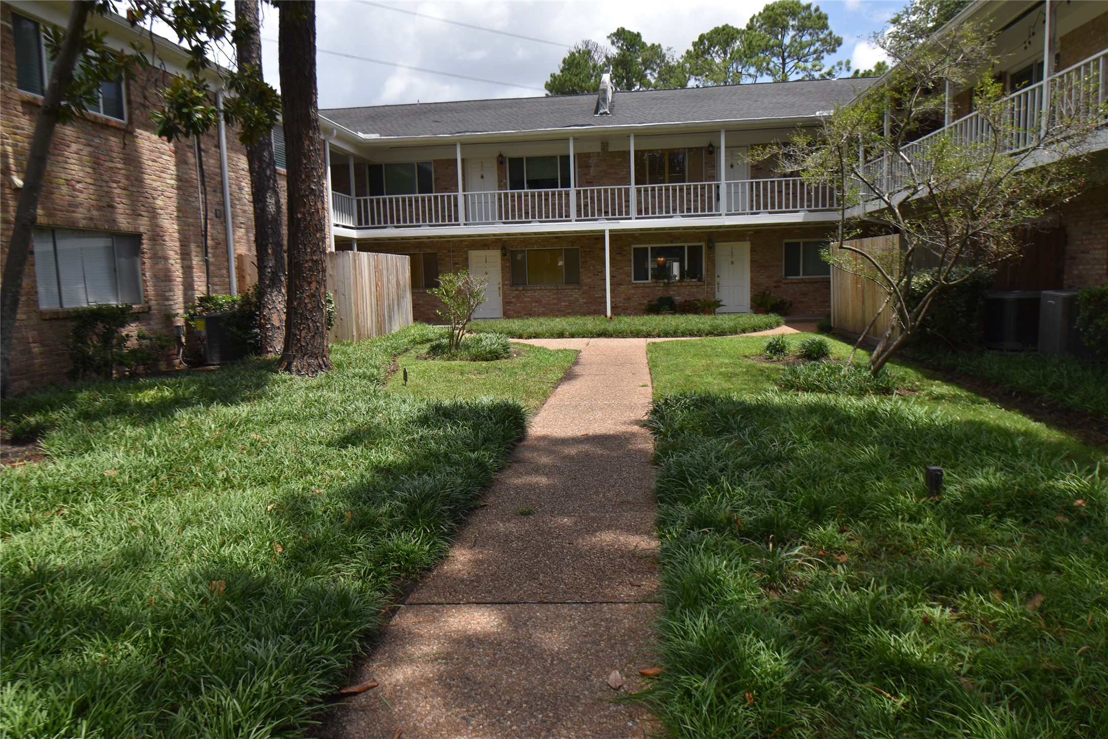 4040 San Felipe Street, Unit 155 Houston, TX 77027 - Photo 2 of 15 a front view of a house with a yard and potted plants