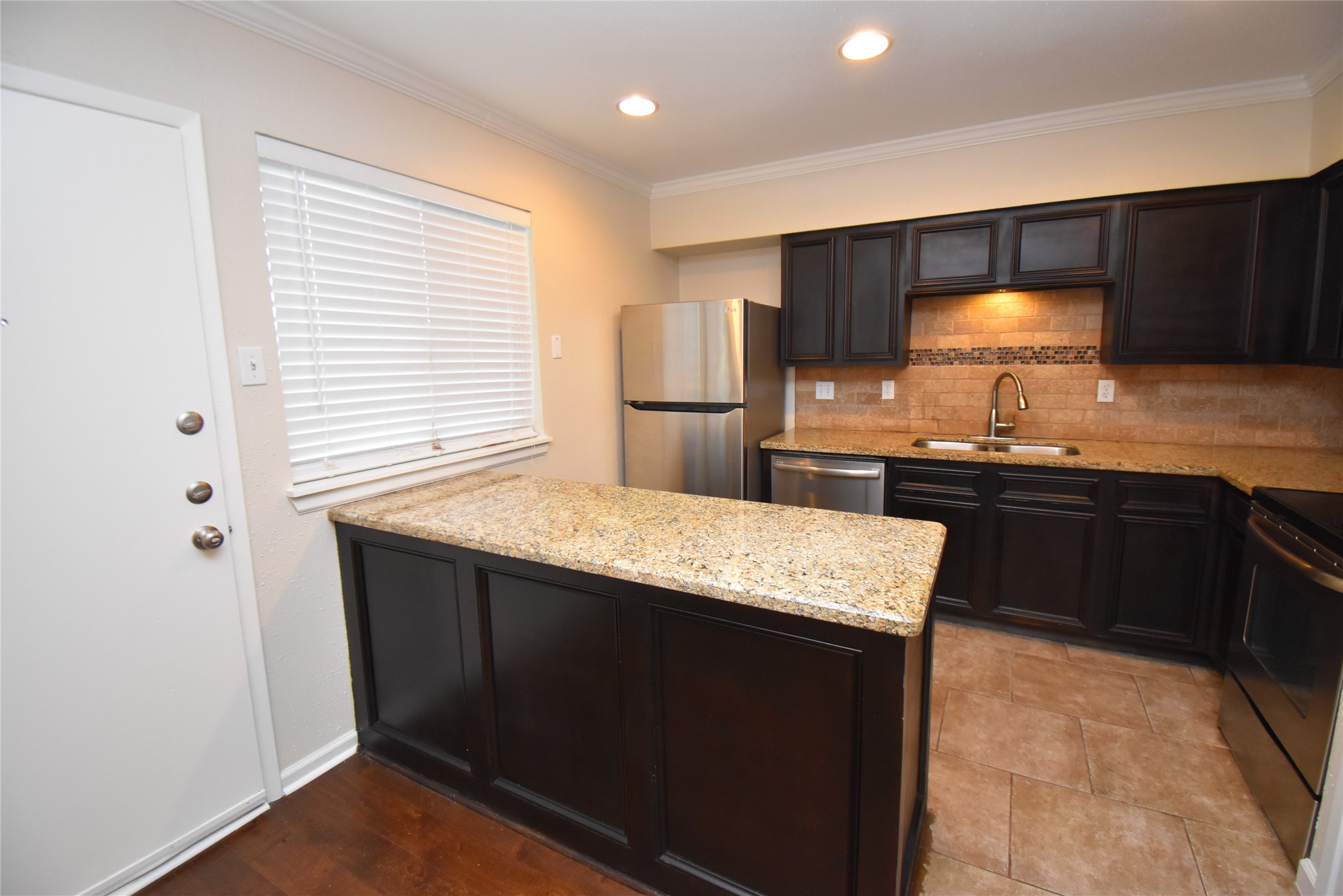 4040 San Felipe Street, Unit 155 Houston, TX 77027 - Photo 7 of 15 a kitchen with stainless steel appliances granite countertop wooden cabinets and a sink