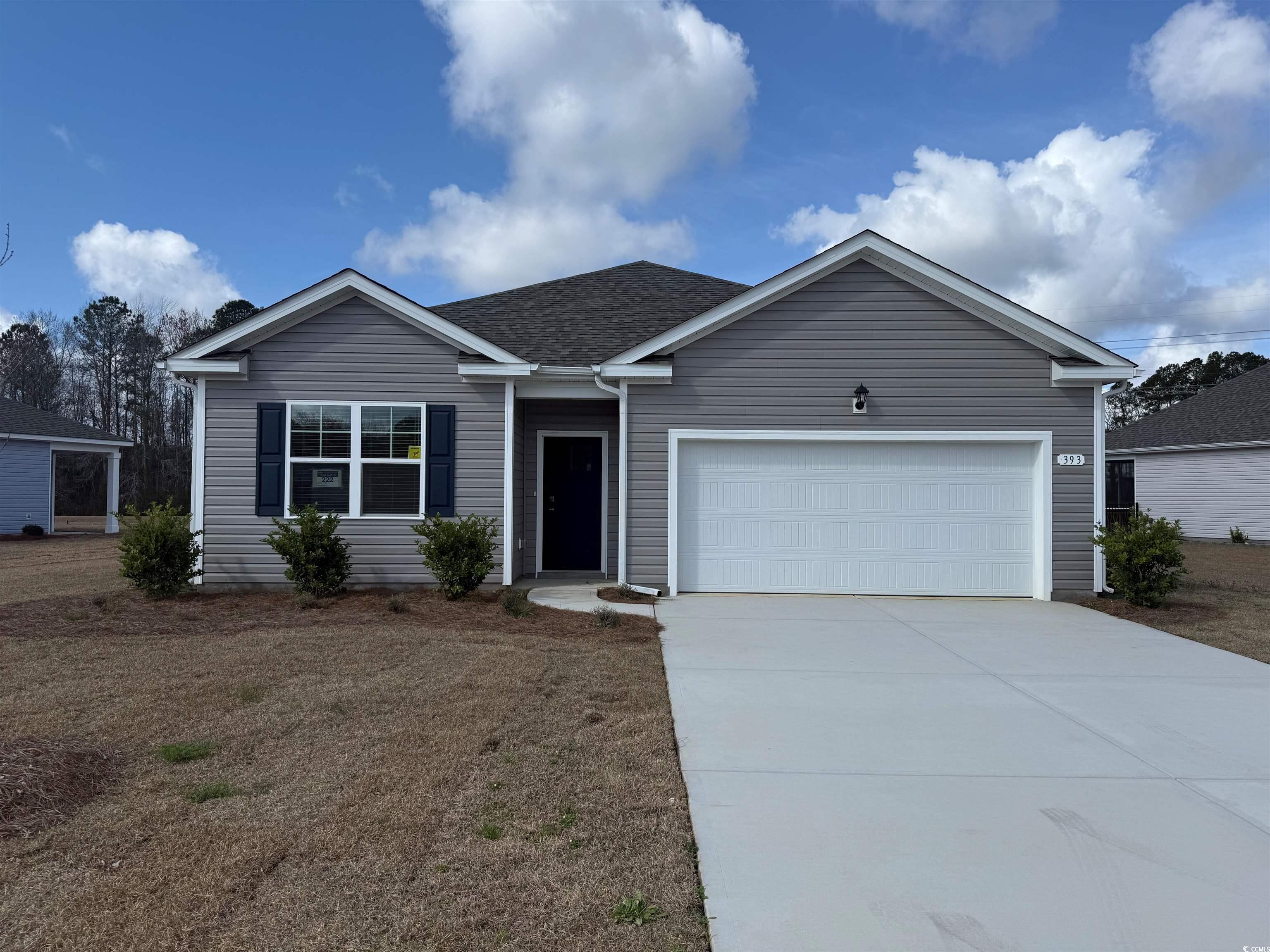 Single story home with concrete driveway, a front lawn, and an attached garage