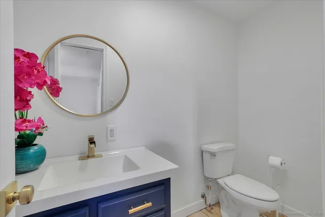 a view of a livingroom with a fireplace a ceiling fan and wooden floor