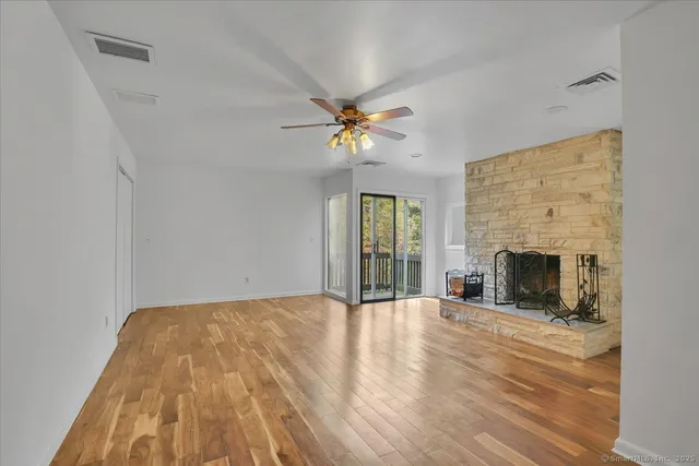 wooden floor fireplace and windows in an empty room