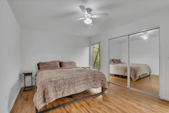 a bedroom with a bed and wooden floor