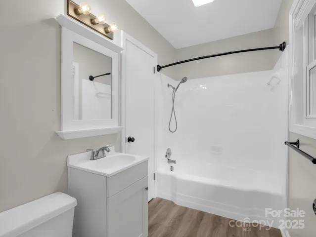 a bathroom with a tub a sink and a mirror