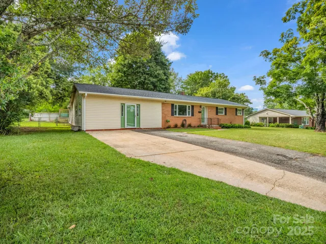 a view of house with yard and green space