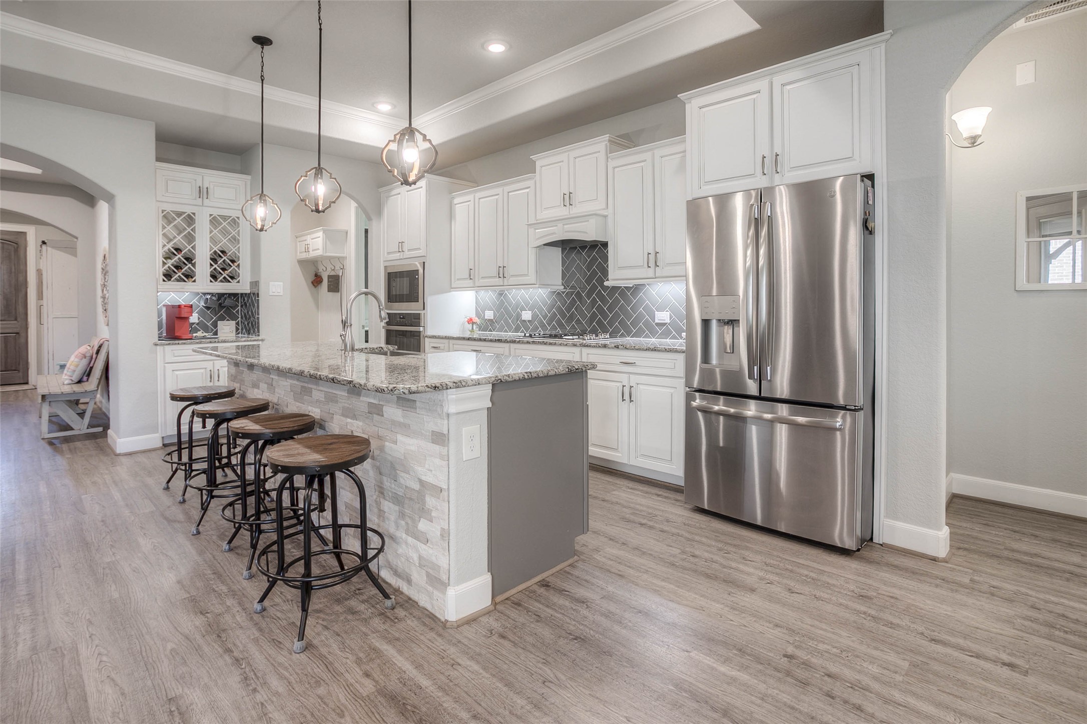 5757 Lakeside Villas Court Conroe, TX 77304 - Photo 1 of 50 a kitchen with stainless steel appliances a refrigerator a stove a sink dishwasher and a dining table with wooden floor