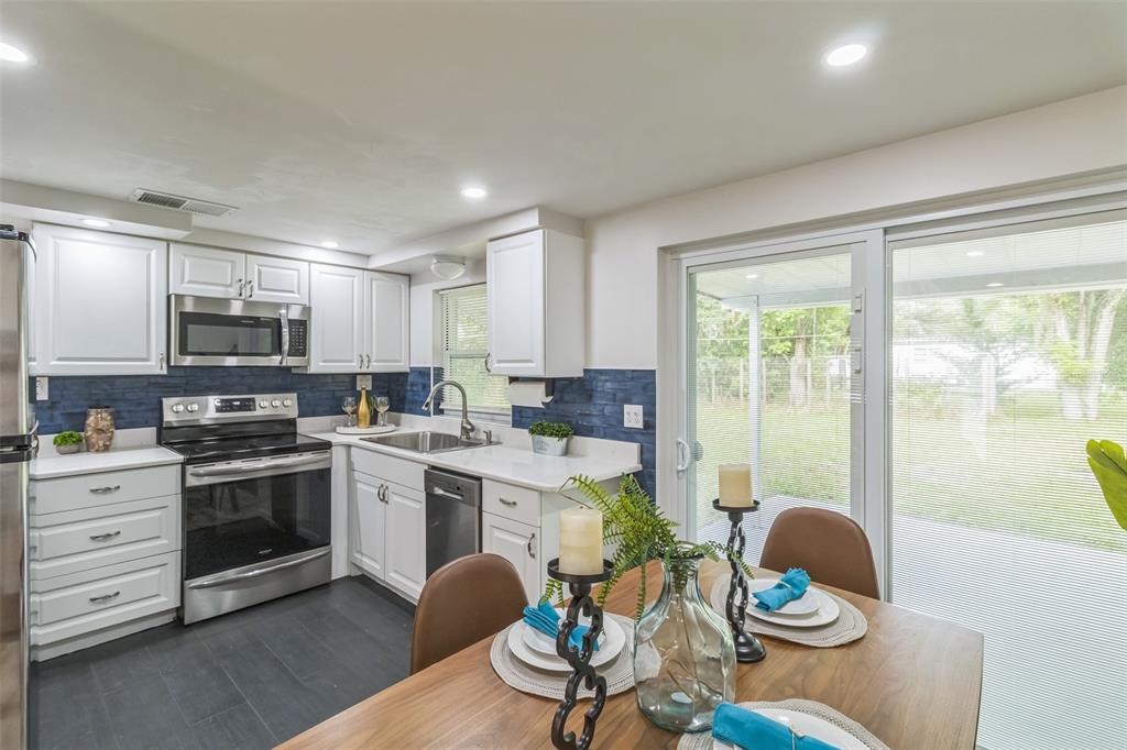 5390 South Manatee Terrace Homosassa, FL 34446 - Photo 11 of 25 a kitchen with a stove a table and chairs