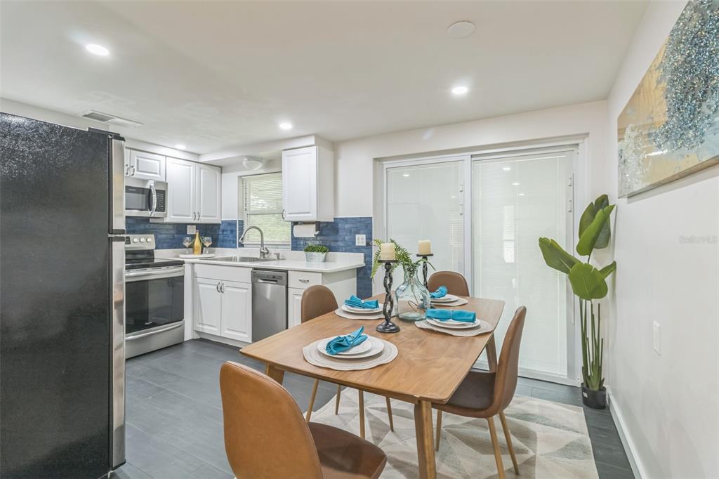 5390 South Manatee Terrace Homosassa, FL 34446 - Photo 12 of 25 a kitchen with a refrigerator a stove a dining table and chairs