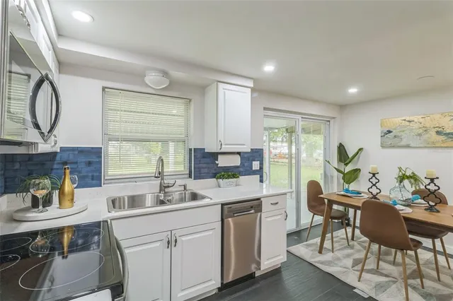 a kitchen with a sink cabinets and dining table chair