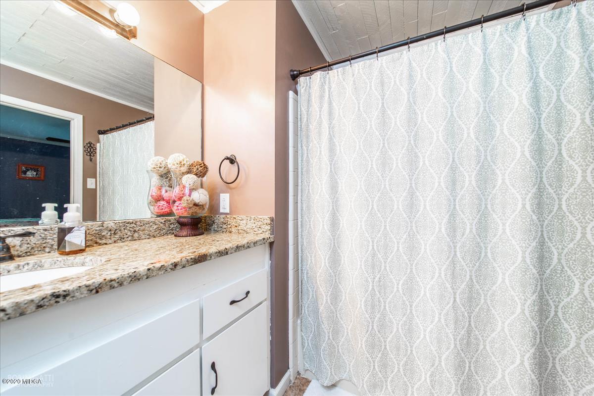 6431 Stapleton Road Macon, GA 31206 - Photo 17 of 29 a bathroom with a granite countertop sink and a mirror