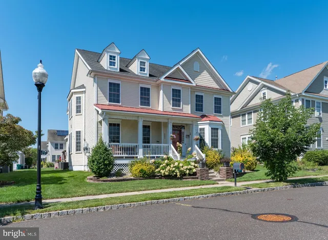 a front view of a house with a yard and trees