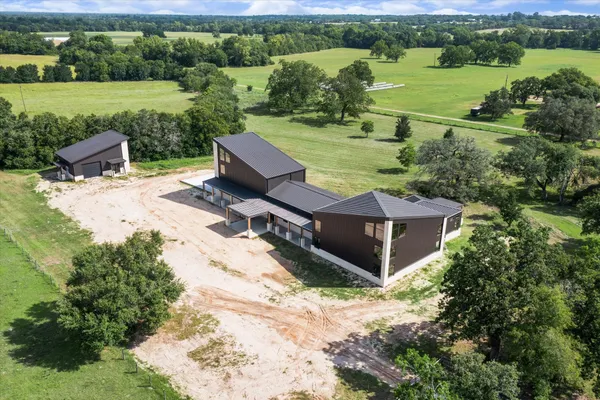an aerial view of a house with big yard