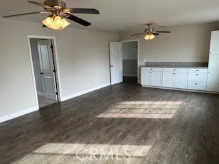 a view of an empty room with wooden floor and cabinet