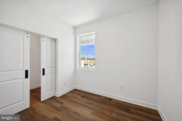 a view of an empty room with wooden floor