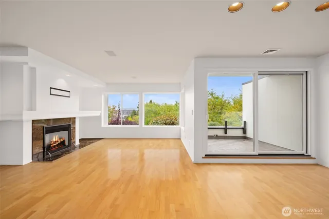 a view of empty room with floor to ceiling window and fireplace
