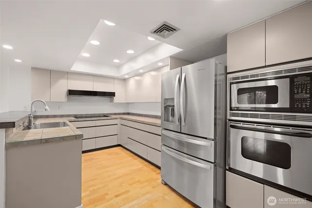 a kitchen with stainless steel appliances a refrigerator sink and microwave