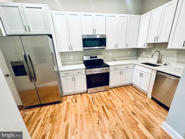 a kitchen with stainless steel appliances a refrigerator sink and microwave