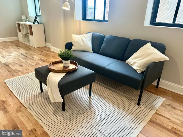 a living room with furniture and a wooden floor