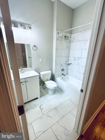 a bathroom with a sink a toilet a mirror and shower