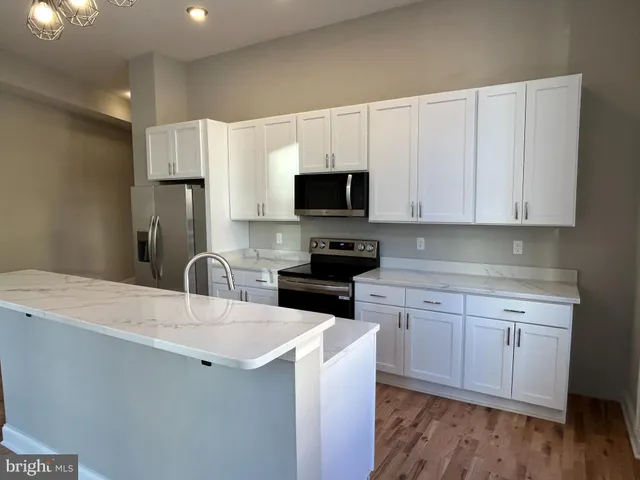 a kitchen with a sink a stove a microwave and cabinets