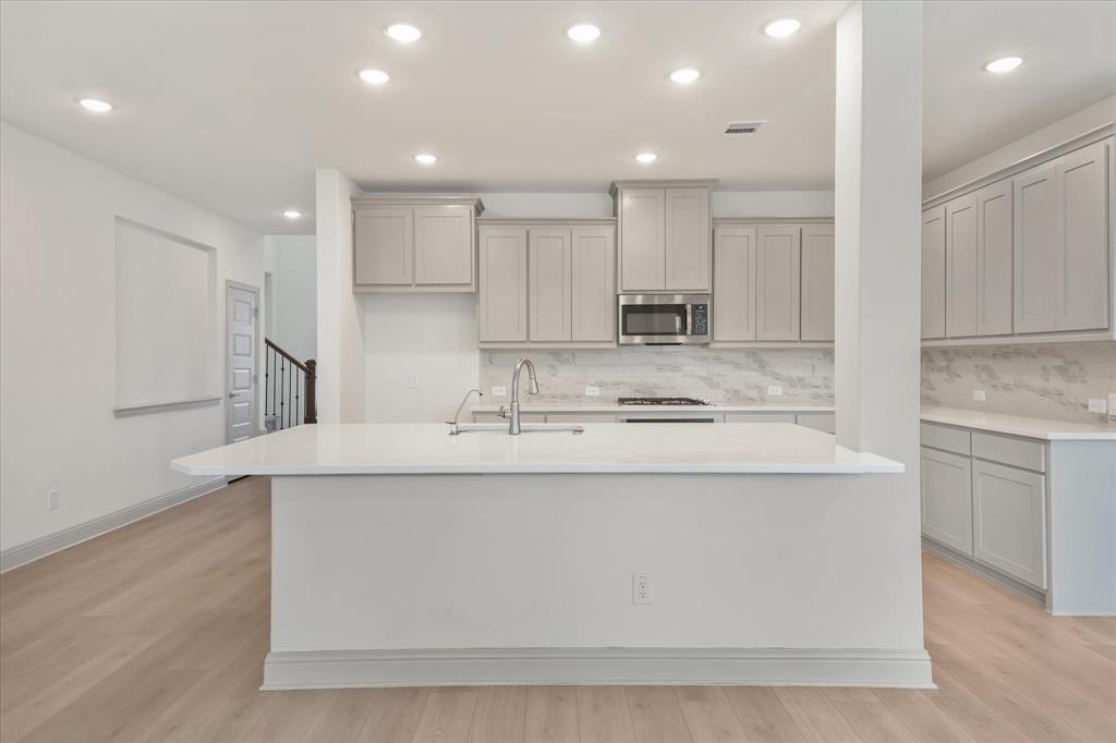3208 Heathrow Road Mesquite, TX 75181 - Photo 3 of 21 a kitchen with kitchen island a sink stainless steel appliances and cabinets
