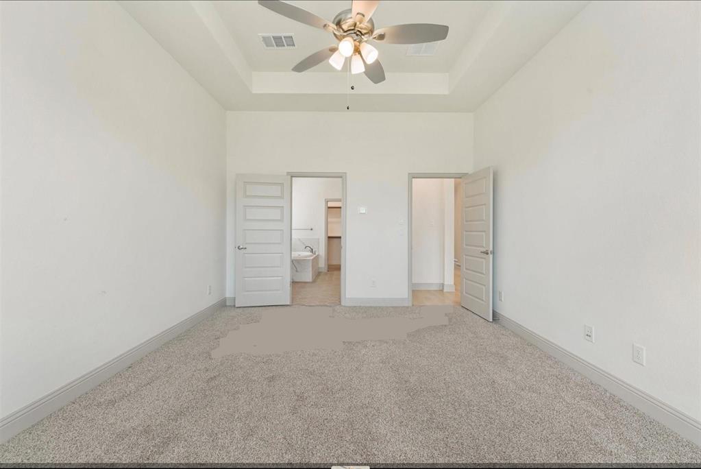 3208 Heathrow Road Mesquite, TX 75181 - Photo 8 of 21 This room features light-colored carpeting, white walls, and a tray ceiling with a ceiling fan