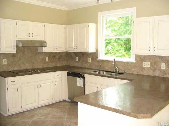 2008 Hilly Ridge Raleigh, NC 27603 - Photo 5 of 10 a kitchen with granite countertop a sink white cabinets and a large window