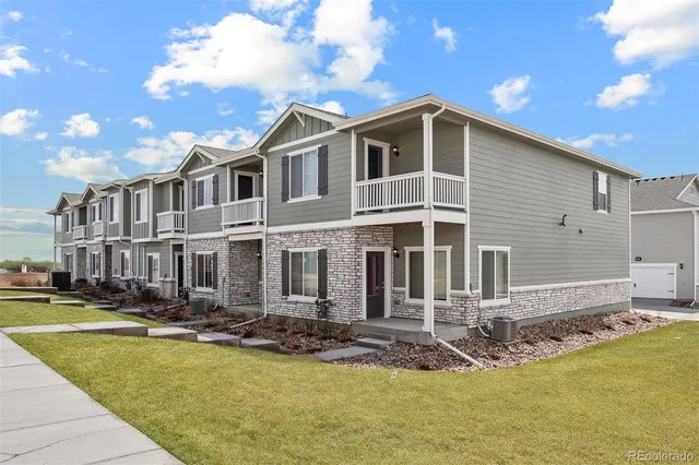 a front view of a house with swimming pool and chairs